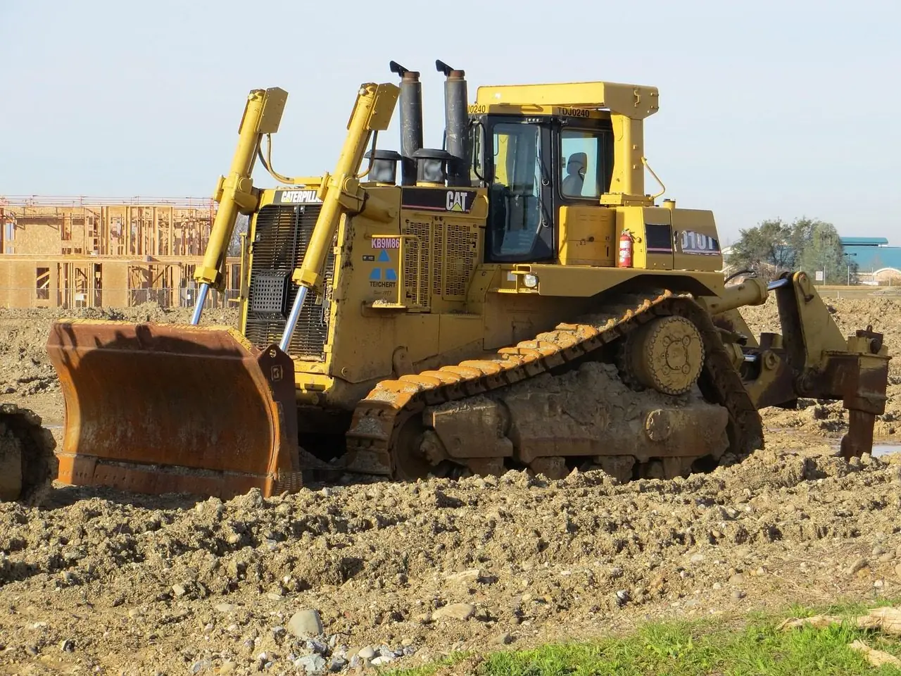 Yellow bulldozer at a house construction site