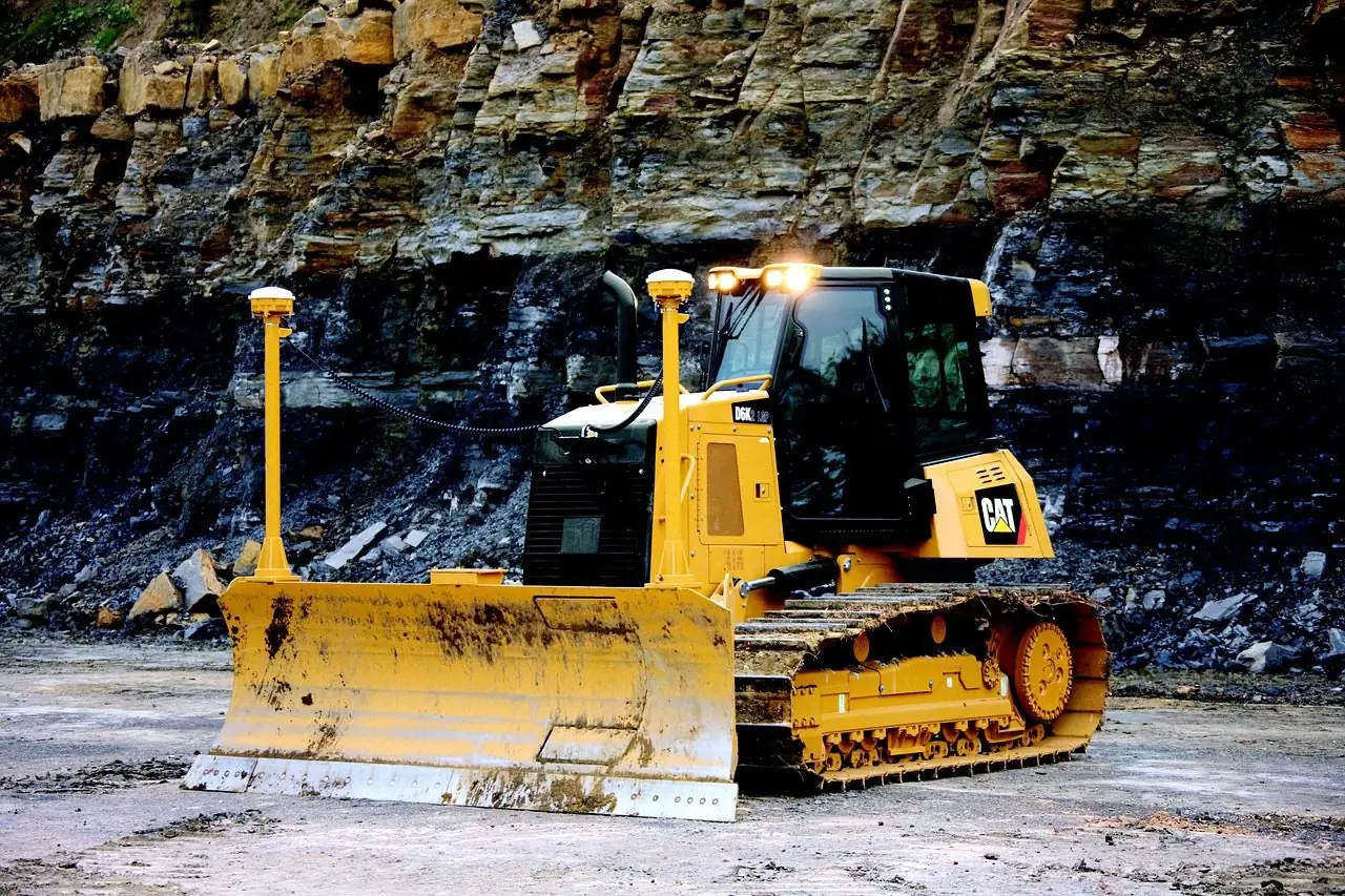 Yellow bulldozer pushing a pile of dirt on a construction site