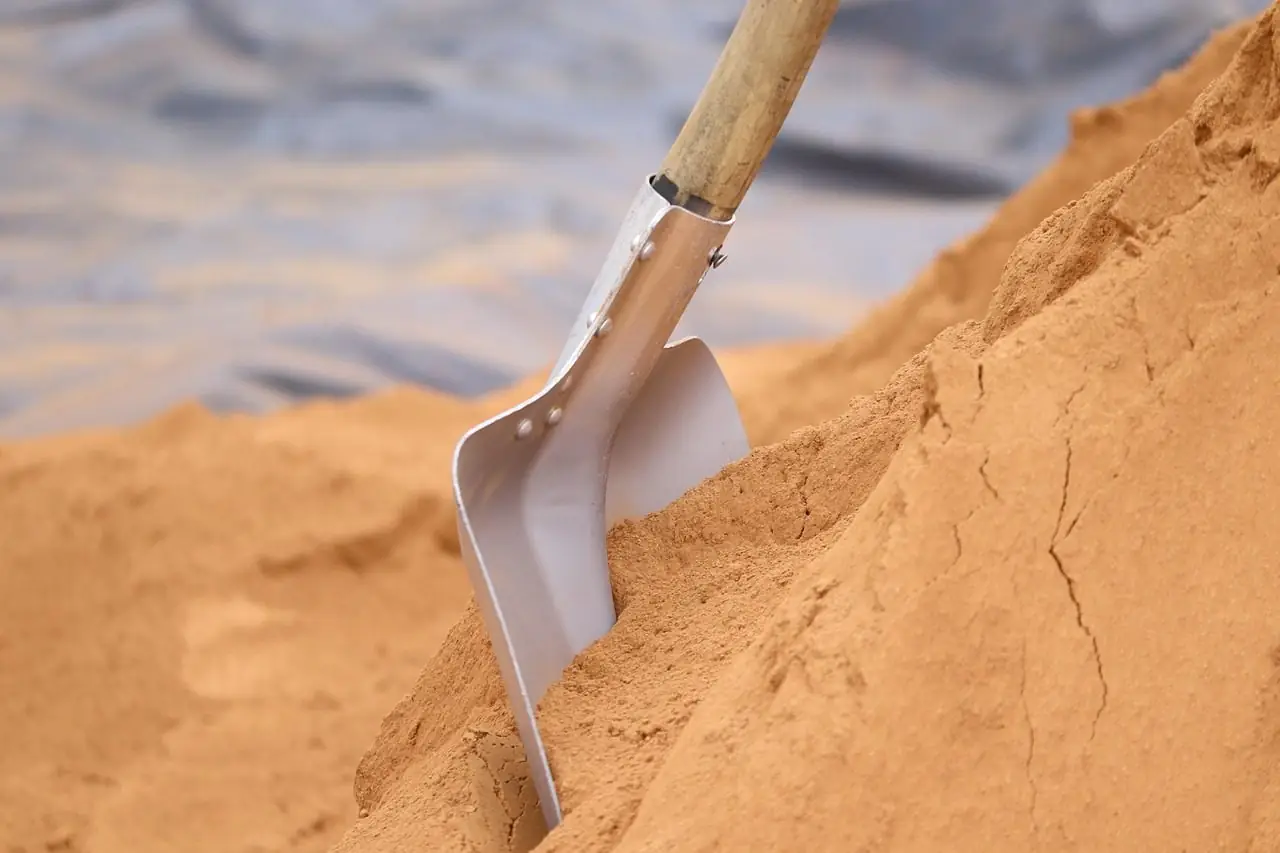Shovel standing in a pile of fine sand